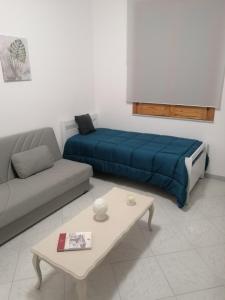Sala de estar con cama y mesa de centro en Montalbano House - Casa Vacanze, en Santa Margherita di Belice