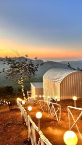 un gruppo di edifici bianchi con luci in un campo di D Classicals a Kodaikānāl