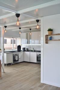 an open kitchen with white cabinets and appliances at La Isleta Nest Hostel in Las Palmas de Gran Canaria