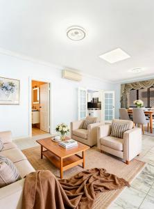 a living room with white furniture and a table at Burwood central home in Sydney