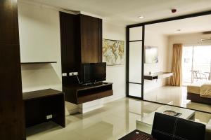 a living room with a television and a room with a bed at Baan Klang Condo Hua Hin in Hua Hin