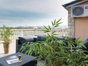 a patio with a couch and a table on a balcony at Apartment Laura mit Pool by Interhome in Stankovci
