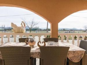 a table with a chicken sitting on a balcony at Apartment Laura mit Pool by Interhome in Stankovci