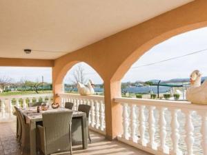 a porch with a table and chairs on a balcony at Apartment Laura mit Pool by Interhome in Stankovci