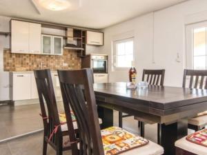 a dining room with a table and chairs in a kitchen at Apartment Laura mit Pool by Interhome in Stankovci +17 photos