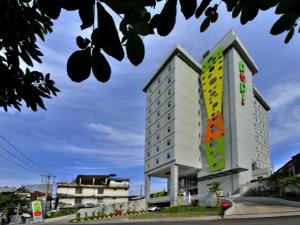 un edificio blanco alto con un letrero. en POP! Hotel Stasiun Kota Surabaya en Surabaya