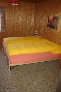 a bed with a yellow mattress in a room at Apartment Davo Tuoi by Interhome in Guarda +4 photos