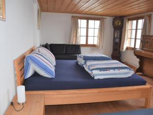 a bedroom with a bed with blue sheets and a couch at Apartment Mätzli by Interhome in Vitznau +3 photos