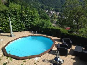 a large blue swimming pool on a brick patio at Apartment Mätzli by Interhome in Vitznau
