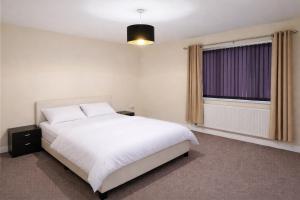 En eller flere senge i et værelse på Cosy 2-Bedroom House