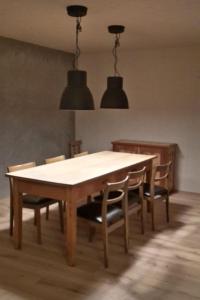 a dining room table with chairs and two lights at Apartment Biala - BioBergün by Interhome in Bergün