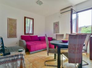 a living room with a pink couch and a table at Villa Marković 2 in Sutomore