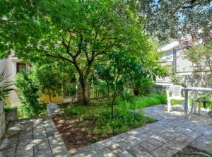 a patio with a tree and a white bench at Villa Marković 2 in Sutomore