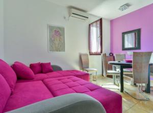 a living room with a purple couch and a table at Villa Marković 2 in Sutomore