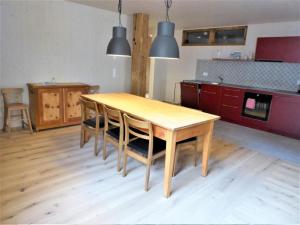 a kitchen with a wooden table and some lights at Apartment Biala - BioBergün by Interhome in Bergün