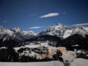 a snow covered mountain range with a town in the foreground at Apartment cajos-ftan by Interhome in Ftan