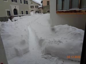 a yard covered in snow next to a house at Apartment cajos-ftan by Interhome in Ftan