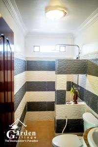 a bathroom with a tub and a toilet and a sink at Garden Village Guesthouse & Pool Bar in Siem Reap