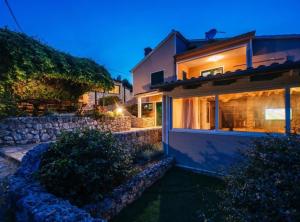 a house with a stone wall next to a building at Holiday Home Villa Rokov in Mali Iž
