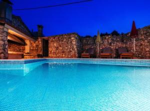 a swimming pool in a villa at night at Holiday Home Villa Rokov in Mali Iž