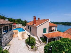 a villa with a swimming pool and a house at Holiday Home Villa Rokov in Mali Iž
