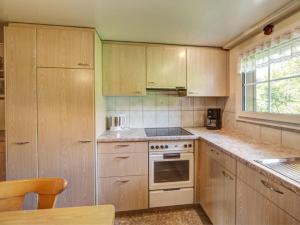 a kitchen with wooden cabinets and a stove top oven at Apartment Hautle by Interhome in Eggerstanden - Appenzell
