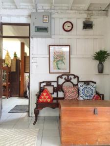 sala de estar con sofá y reloj en la pared en Many Trees, en Bangkok