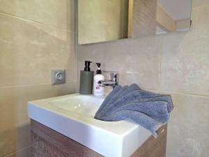 a bathroom sink with a blue towel on it at Infinity Torremolinos Spacious 2 Bedroom, 2 Bathroom Apartment by NAMASTE ELITE in Torremolinos +38 photos