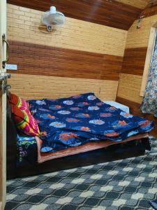 a bed with a blue comforter in a room at Gulmarg View Guest House in Khor +6 photos