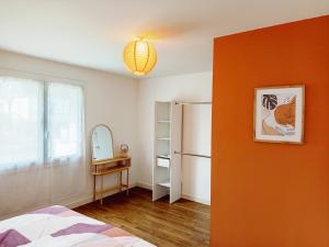 een slaapkamer met een oranje muur en een koelkast bij Porh tramesse in Saint-Thuriau