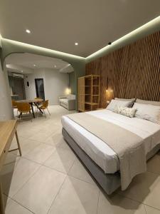 a bedroom with a large bed and a dining room at Chanioporta suites in Heraklio