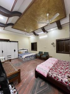 a room with two beds and a ceiling at Pragya Farmhouse in Jodhpur