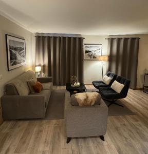 een woonkamer met twee banken en twee stoelen bij Spacious ski-in ski-out renovated apartment 4-6 pax, 161 Sources de Marie Arc 1950 in Arc 1950