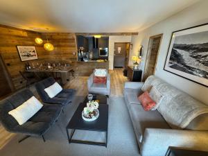 een woonkamer met een bank en een tafel bij Spacious ski-in ski-out renovated apartment 4-6 pax, 161 Sources de Marie Arc 1950 in Arc 1950 +56 foto's