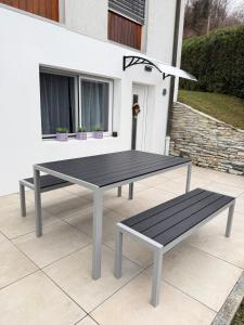 a picnic table and bench on a patio at Torrent House in Bouveret