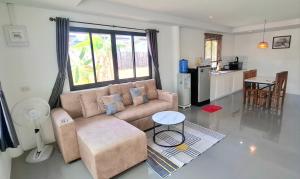 a living room with a couch and a kitchen at Lanta Cozy House 02 in Ko Lanta