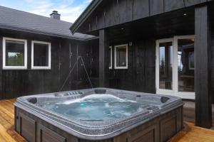 ein Whirlpool im Hinterhof eines Hauses in der Unterkunft Cabin With Mountain View In Solberglia in Østby