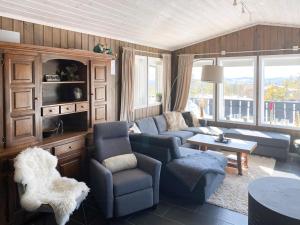 ein Wohnzimmer mit Sofa, Stühlen und einem Tisch in der Unterkunft Cabin With Mountain View In Solberglia in Østby