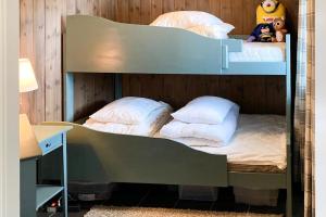2 Etagenbetten in einem Zimmer mit einem Schreibtisch in der Unterkunft Cabin With Mountain View In Solberglia in Østby
