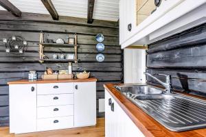 eine Küche mit weißen Schränken und einer Spüle in der Unterkunft Family-Friendly Log Cabin With Panoramic View in Østby + 25 Fotos