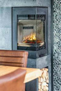 einen Steinkamin mit Kamin in der Unterkunft Family-Friendly Log Cabin With Panoramic View in Østby