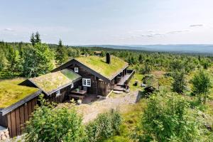 ein Bild eines Hauses mit einem Grasdach in der Unterkunft Family-Friendly Log Cabin With Panoramic View in Østby