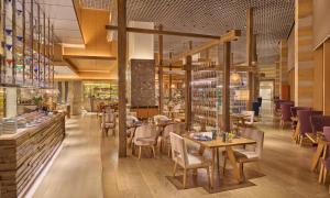 een restaurant met tafels en stoelen en een bar bij Mandarin Oriental Al Faisaliah, Riyadh in Riyad