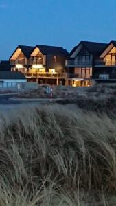 a house with a field of grass in front of it at Hotel og Restaurant Havbadet in Thisted