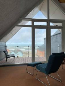 a room with a large window with a chair and a bench at Hotel og Restaurant Havbadet in Thisted