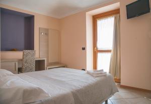 een slaapkamer met een groot bed en een raam bij Il Poggio Agrisport in Poirino