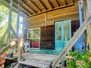 an outside view of a wooden house with a blue door at Casita isleña in Tigre