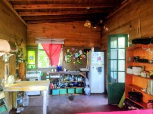 a kitchen with a table and a refrigerator at Casita isleña in Tigre +5 photos