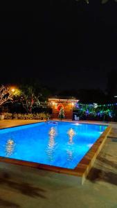 een groot blauw zwembad met verlichting bij Nan poolvilla in Ban Kot