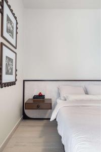 - une chambre blanche avec un lit et une table de nuit dans l'établissement The Poet Den with 120 inch screen, à Yas Island